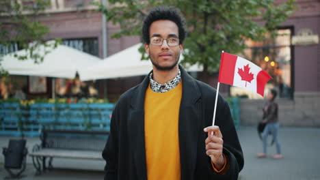 man holding canadian flag in city street