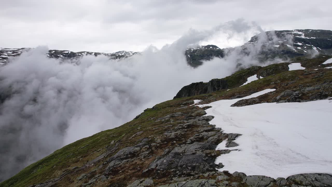 nubes que se mueven desde el valle sima entre picos rocosos en eidfjord
