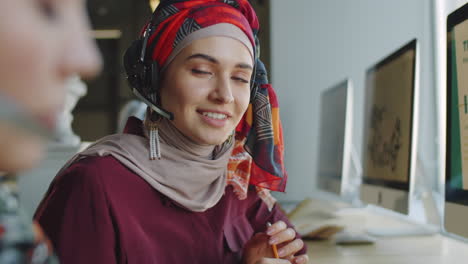 portrait of muslim woman in hijab at work in call center