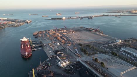 orbital aerial drone of a busy industrial port during sunset