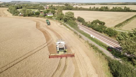 Aerial-footage-of-a-combine-harvester-and-tractor-harvesting-a-wheat-crop