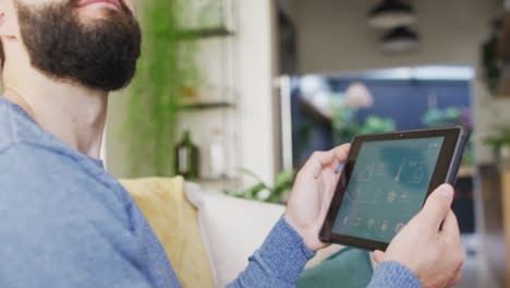 video of happy caucasian man using smart home interface on tablet at home