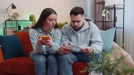 stressed man woman looking at unpaid bank debt loan doing paperwork planning budget throws bills