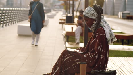 Woman-Using-Computer-on-Bench-Outdoors