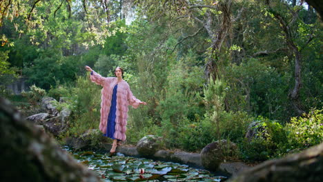 modelo de moda posando estanque bosque cubierto de lirios de agua. mujer de pie en el lago
