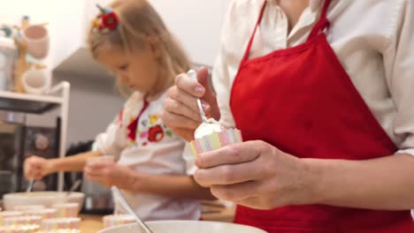 mom and daughter baking cupcakes