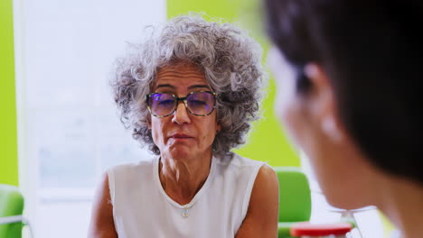 Female-boss-talking-at-an-informal-team-meeting,-close-up