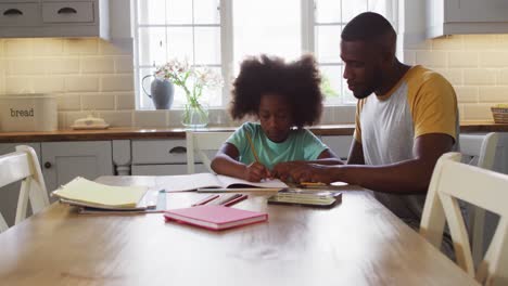 Afroamerikanische-Tochter-Und-Ihr-Vater-Erledigen-Gemeinsam-Ihre-Schulaufgaben-Am-Küchentisch