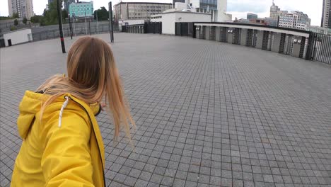 mujer con chaqueta amarilla en la plaza de la ciudad