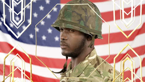 Adjusting helmet, soldier in camouflage with American flag behind him