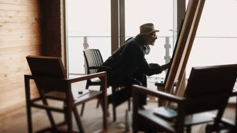 artist painting in a studio with ocean view