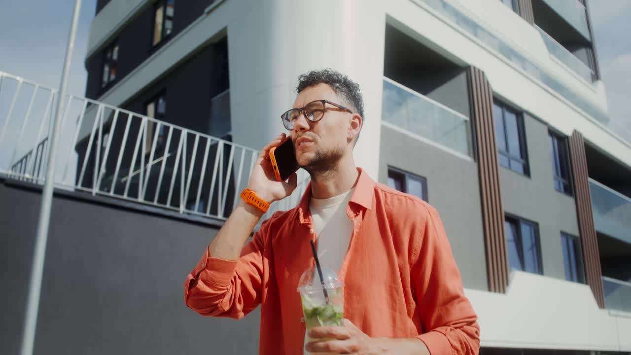 hombre hablando por teléfono y bebiendo un cóctel