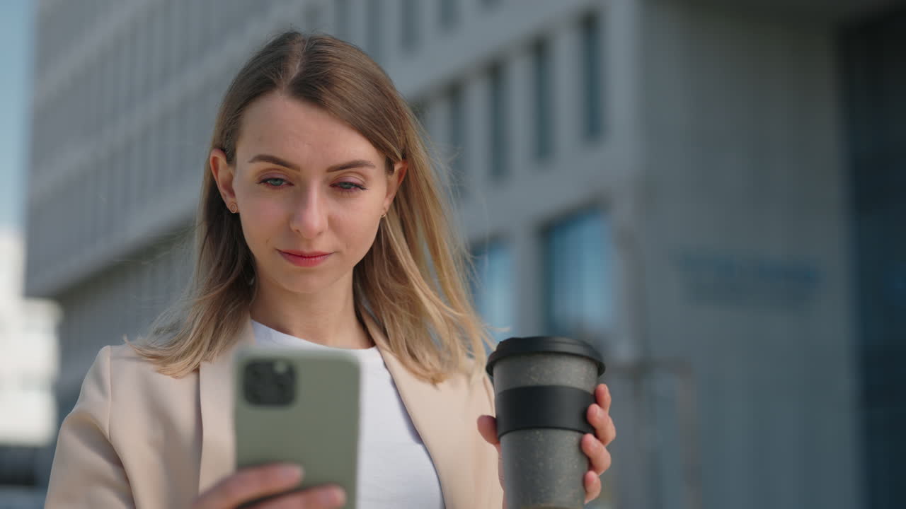 Donna sorridente che si gode una pausa caffè mentre usa lo smartphone
