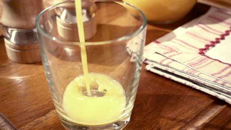 Jugo-De-Naranja-Vertido-En-Un-Vaso,-El-Desayuno-De-La-Mañana.-Cámara-Lenta-Con-Seguimiento-De-Rotación.