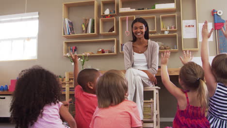 Pupils-At-Montessori-School-Raising-Hands-To-Answer-Question