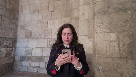 female visitor holding smartphone at jaffa gate in old jerusalem. slow motion.