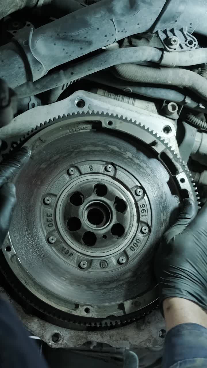 Auto Mechanic Inspecting Flywheel of a Car Engine