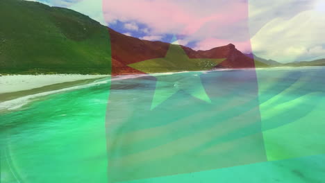 digital composition of cameroon flag waving against aerial view of waves in the sea