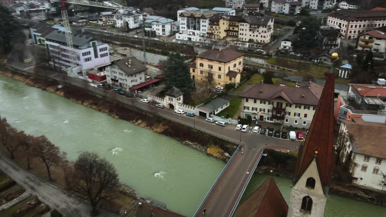 vista orbital sobre la torre de la iglesia de la ciudad de chiusa klausen, tirol del sur, bolzano, italia