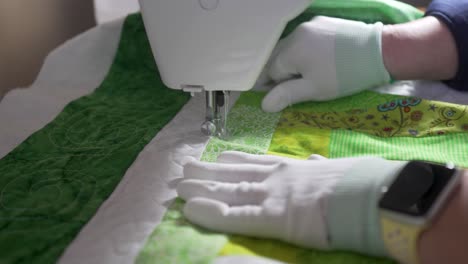 costura en un patrón intrincado en un edredón casero usando una máquina de coser - cámara lenta