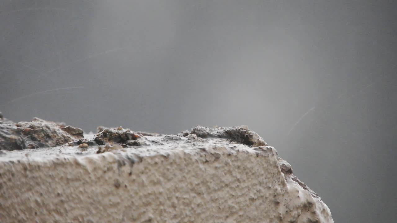 뇌우 동안 빗방울과 우박이 석고와 건물 벽돌에 떨어지고 떨어지는