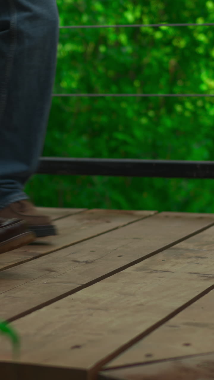Close-up of Two People Walking on a Wooden Bridge
