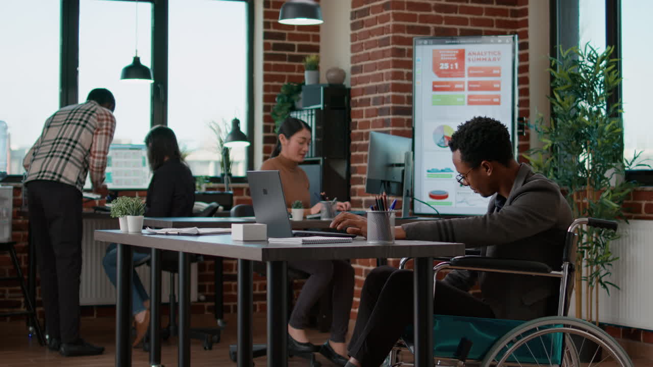 Man working in disability friendly office with business charts