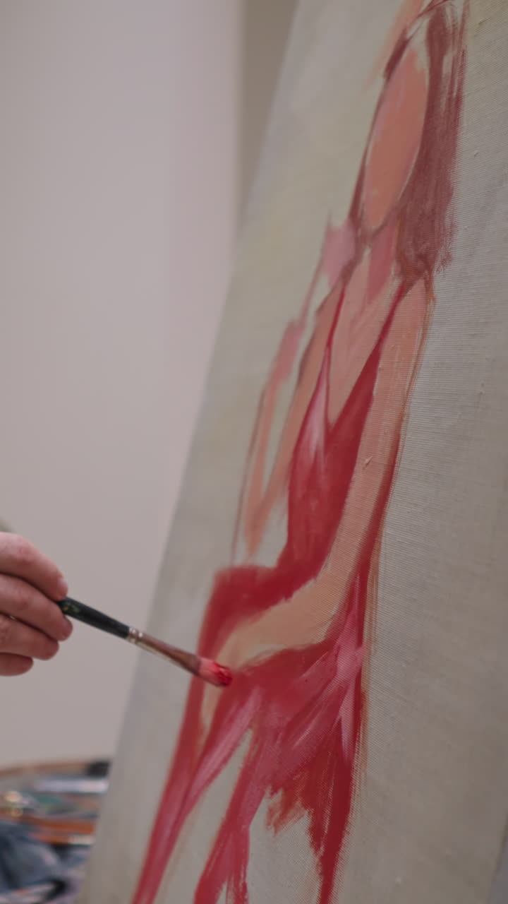 el hombre dibuja a la mujer de los sueños en primer plano en el estudio. el artista con acrilo pinta la paleta a mano trabaja sobre el retrato en el taller. el pintor crea obras de arte coloridas