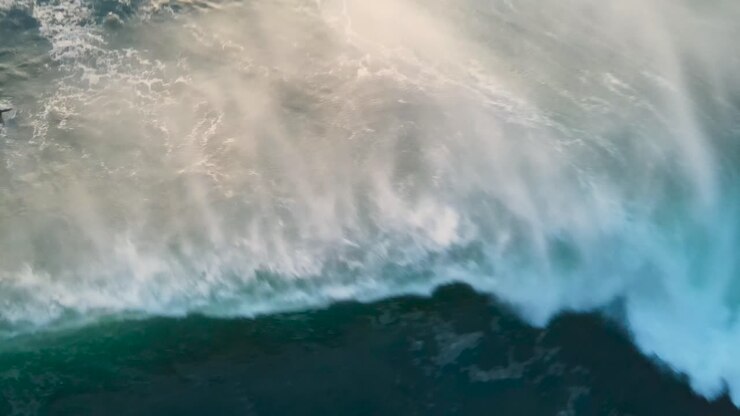 Aerial view of green wave braking