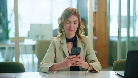 young businesswoman working on her phone in a modern office