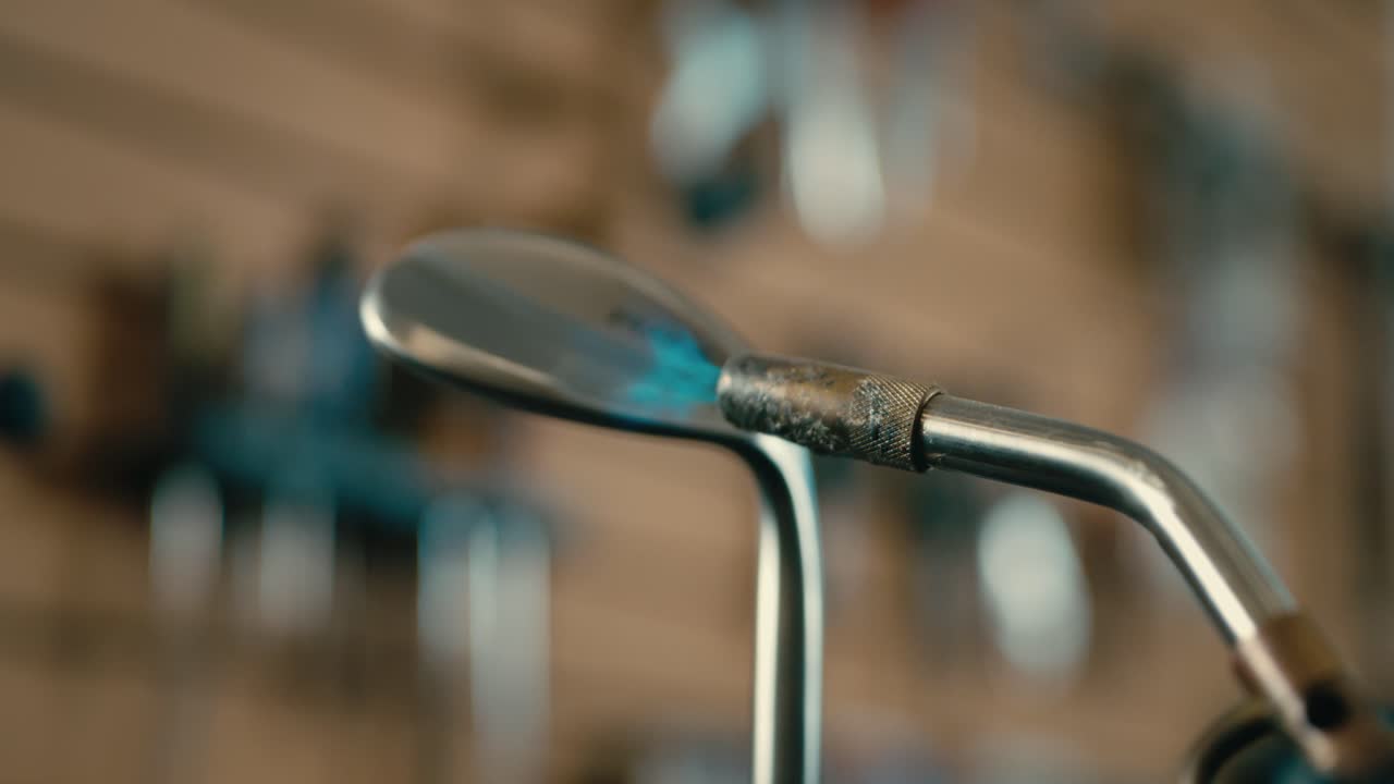 llama quemando una cuña en la tienda de golf, casado constructor de clubes cerca de las llamas en cámara lenta en 4k