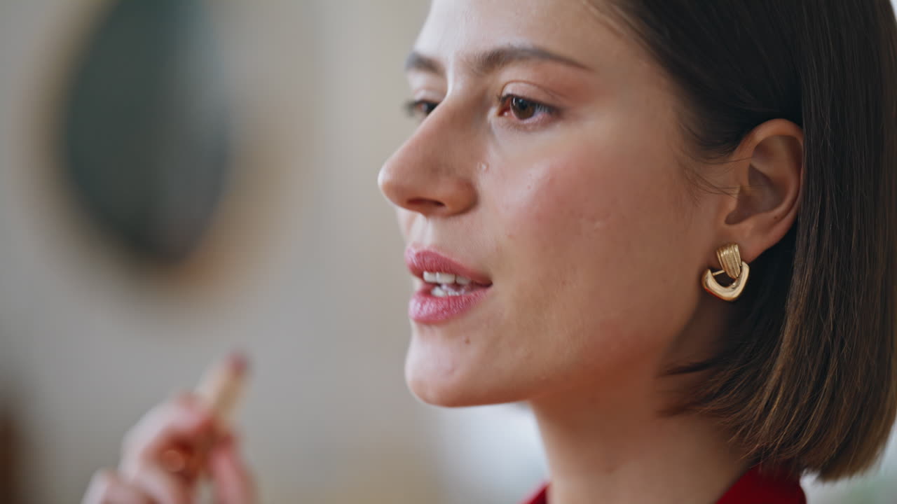 Lady applying red lipstick sending kiss to mirror reflection closeup portrait