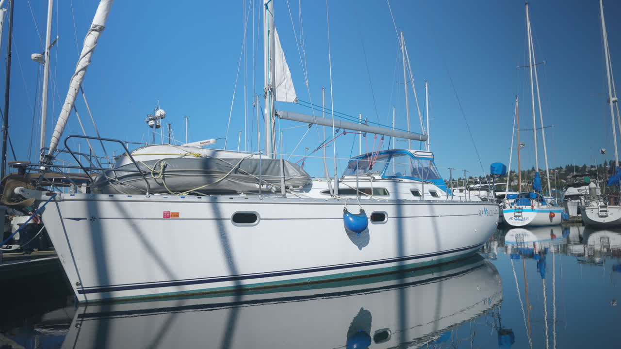 Primer plano de un barco en aguas tranquilas del océano en las terminales de cruceros de Seattle, WA, EE. UU., en un día soleado con muchos barcos detrás.