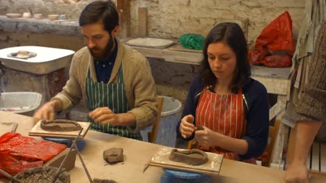 Male-and-female-potters-molding-a-clay