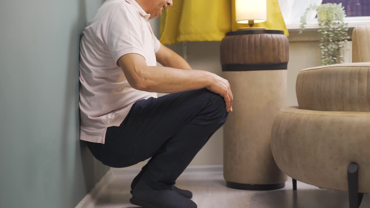 viejo deprimido. se sienta junto a la pared.