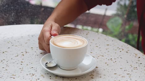 mano alcanzando una taza de café