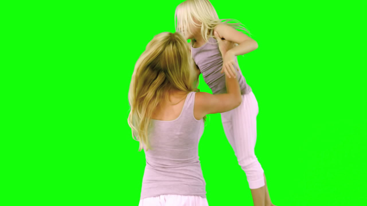 Mãe levantando e girando a filha em tela verde