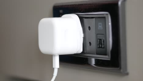 enchufe blanco en una toma de corriente de pared