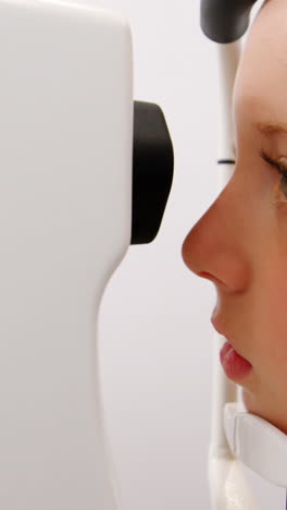 una optometra examinando a un paciente joven con una lámpara de hendidura