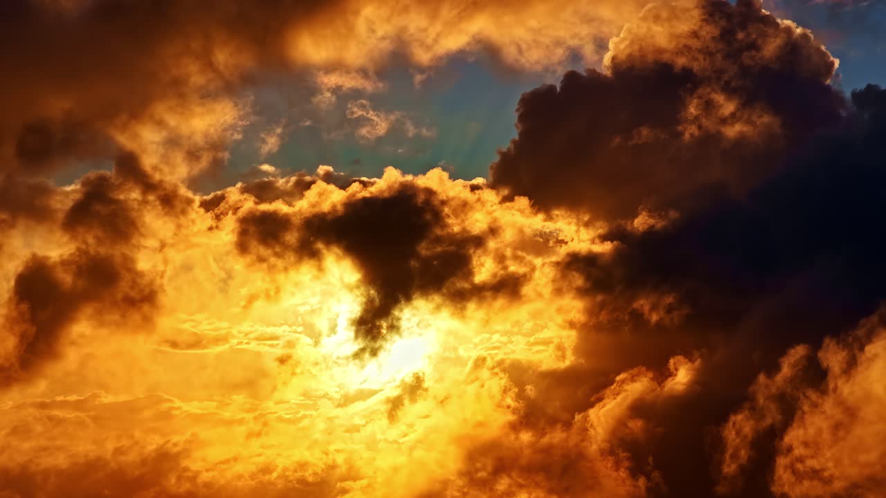 A striking sky filled with thick clouds illuminated by golden sunlight during sunrise or sunset