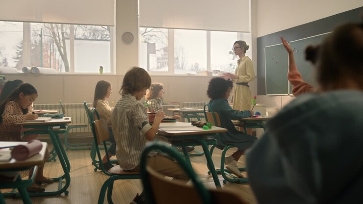 Teacher teaching students in classroom. Kids studying in auditorium at school