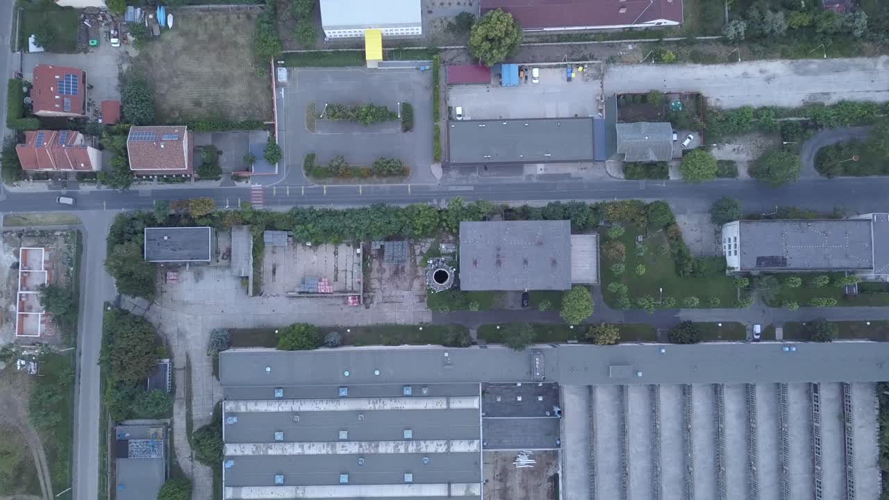 Aerial climbing shot of an Old industrial park with high chimney in a sub-urban territory.