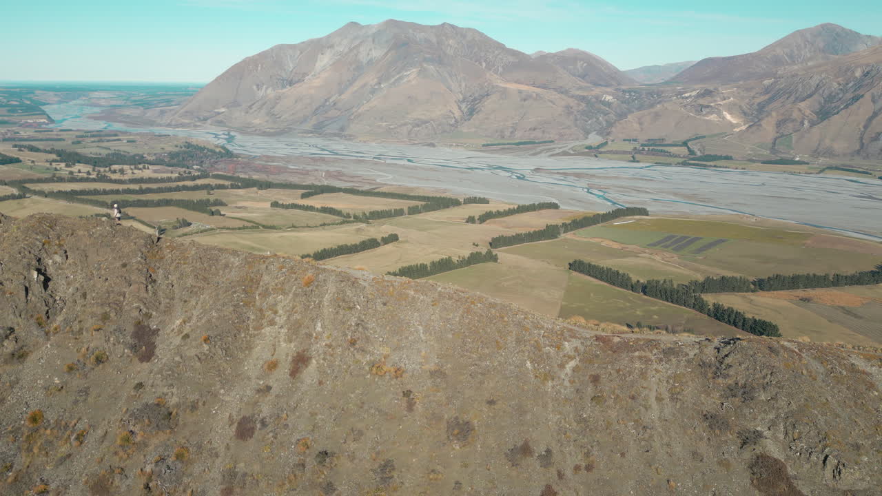 hombre caminando a lo largo de la cresta de las montañas rocosas en canterbury nueva zelanda