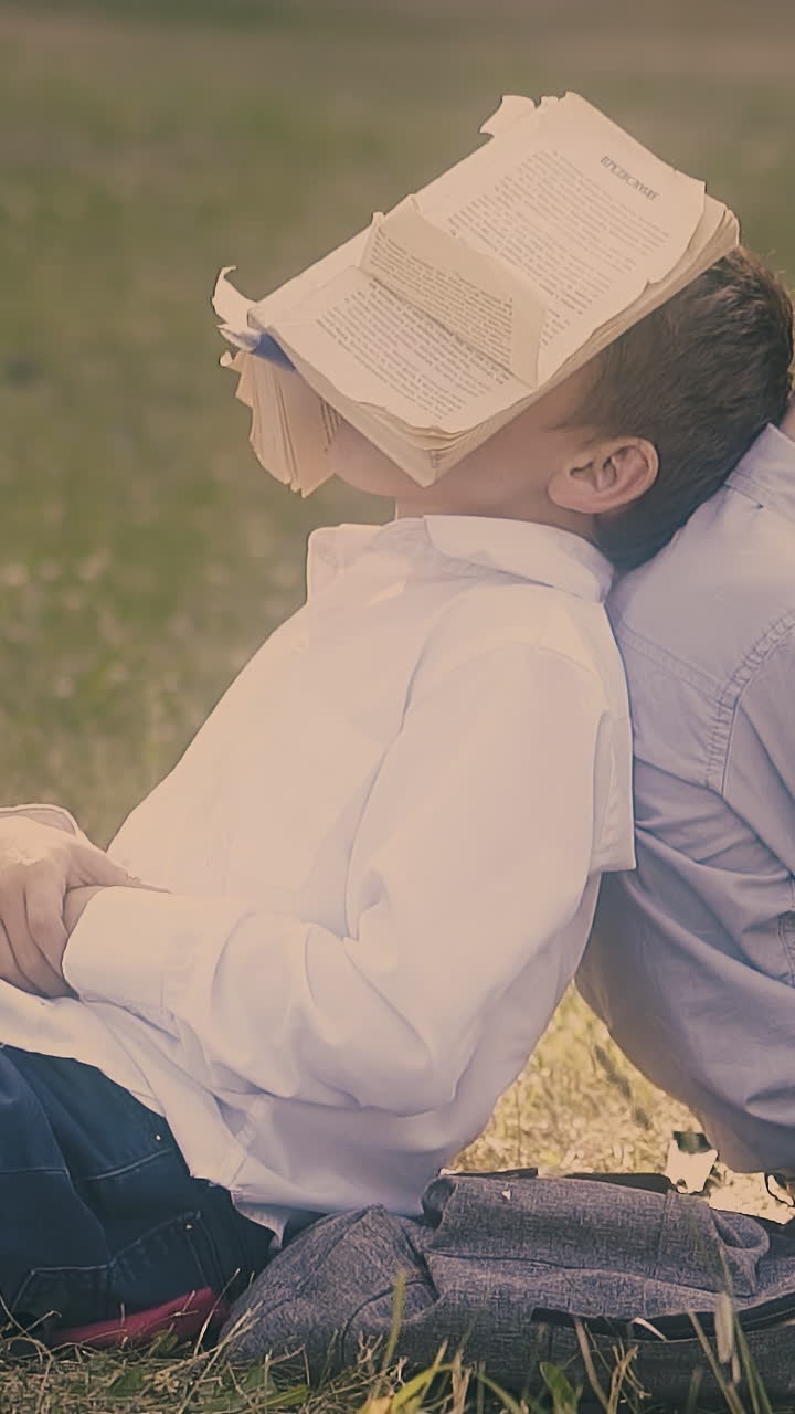 tired little friends wearing school uniform prepare for exam and sleep with books on face close view slow motion