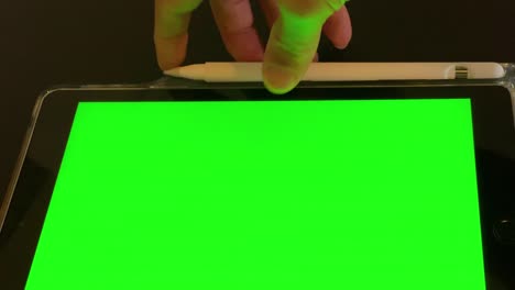 Man-looking-at-tablet-with-green-screen