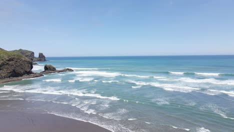 Océano-Turquesa-Y-Olas-Espumosas-En-La-Playa-De-Bethells,-Auckland,-Isla-Norte,-Nueva-Zelanda---Toma-Aérea-De-Drones