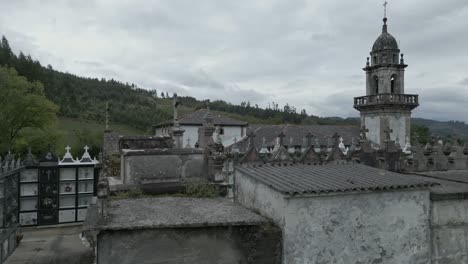 Aerial-low-pan-right-of-cemetery-in-San-Xurxo-de-Moeche-parish,-Spain