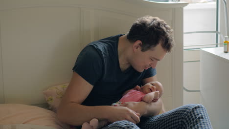 loving father holding newborn daughter and kissing her