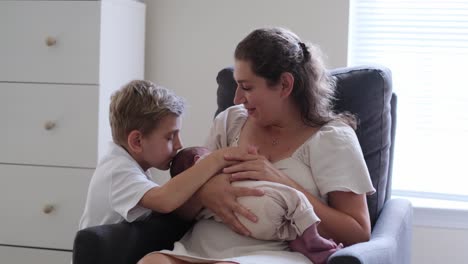 a devoted mother lovingly nurses her infant while her young son beams admiring the sweet moment they a devoted mother lovingly nurses her infant while her young son beams admiring the sweet moment they share together