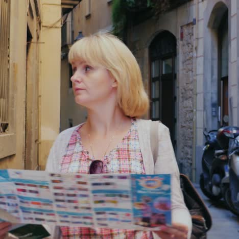 A-woman-with-a-map-in-her-hands-walks-through-the-narrow-streets-of-the-Gothic-quarter-in-Barcelona-1